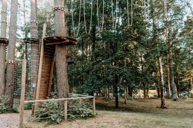 Çam ormanlarında çok renkli oyun kompleksi olan boş oyun alanı, yaz bulutlu bir günde panorama