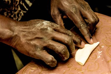 Restoranın mutfağındaki şef, bir tencerede pişirilmesi için lezzetli bir hamur ve et yemeği hazırlıyor.