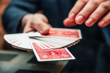 Sihirbaz kart numarası gösteriyor, kumarhane oynayan adam, el ele tutuşup kağıt oynuyor.