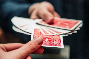 Sihirbaz kart numarası gösteriyor, kumarhane oynayan adam, el ele tutuşup kağıt oynuyor.