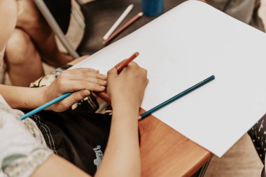 Kağıda renkli kalemle resim çizen çocuk, anaokulunda resim çizen çocuk, anaokulu eğitimi alan çocuk.