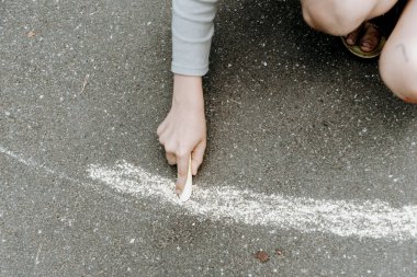 Asfalta renkli tebeşirle resim çizen çocuk, anaokulunda resim çizen çocuk, anaokulu eğitimi alan çocuk.