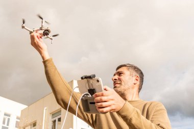 İnsansız hava aracı operatörü gökyüzünden el, fotoğraf ve video ile İHA 'yı yakalıyor.