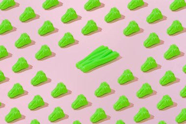 Yaratıcı soyut yaz salatası ve pırasa desenli düz pembe arka plan minimalizmi üzerine uzanır.