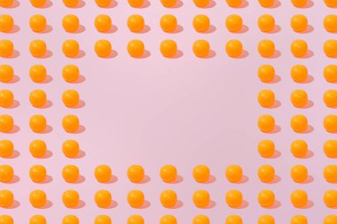 Yaratıcı turuncu desenli düz, metin için kopyalama alanı olan pastel pembe arkaplan minimalizmi üzerinde yatıyordu