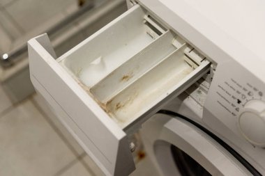 Kirli tepsi çekmecesi eski çamaşır deterjanı ve kireçtaşı kaplı katı su yüzünden.