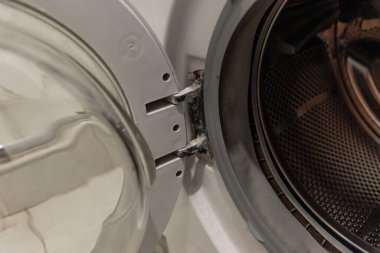 Çamaşır makinesinin menteşeleri sert su nedeniyle kireçtaşı ile kaplıdır.