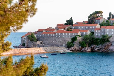Arka planda Adriyatik Denizi, güneşli bir yaz gününde manzarası olan Sveti Stefan adasındaki evleri görmek