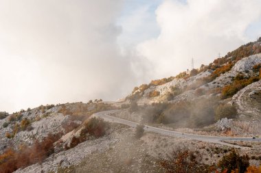 Bulutlu bir sonbahar gününde Lovcen Dağı 'nın tepesinde bir dağ arabası.
