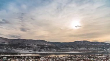 Günbatımında hızlandırılmış bulutlar Sibirya 'nın Krasnoyarsk kentindeki Yenisei Nehri' nin arka planını hareket ettiriyor.