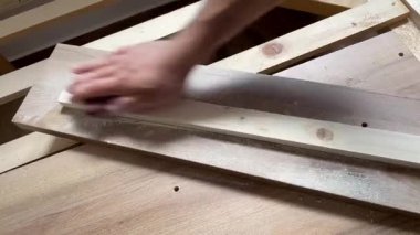 Marangoz atölyede ahşap blok zımparalıyor, el yapımı mobilyalar yapıyor.