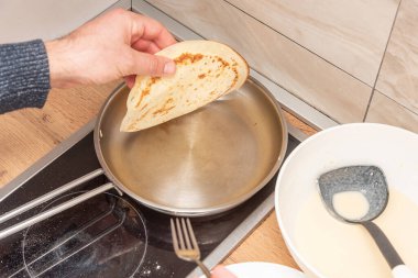 Kitchener krep tarifi, hamur ve kızartma tavasını mutfak masasında pişiriyor.