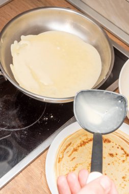 Kitchener krep tarifi, hamur ve kızartma tavasını mutfak masasında pişiriyor.