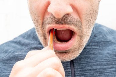 Genç adam banyoda dişlerini fırçalıyor, günlük yaşam tarzı güzellik rutini.