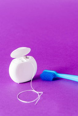 Diş ipi ve diş fırçası ile mor arkaplan üzerine yazılar için yaratıcı kopya alanı, sağlıklı oral konsept