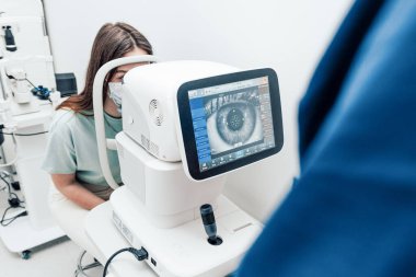 Göz doktoru tarafından klinikte muayene edilen hasta, tıbbi ekipman kontrol görüşü, göz kapama.