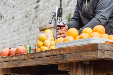 Yazın dışarıda portakallardan ve limonlardan taze sıkılmış meyve suyu yapan adam sağlıklı beslenmek ve yaşam tarzı için detoks içecekler.