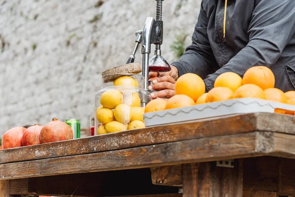 Yazın dışarıda portakallardan ve limonlardan taze sıkılmış meyve suyu yapan adam sağlıklı beslenmek ve yaşam tarzı için detoks içecekler.