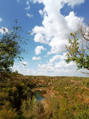 Blue sky with white clouds over rural landscape, natural background with copy space, calm summer day.