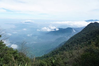 Bulutlu puslu dağ sırası ve uzak bir kıyı şeridi, Vietnam.