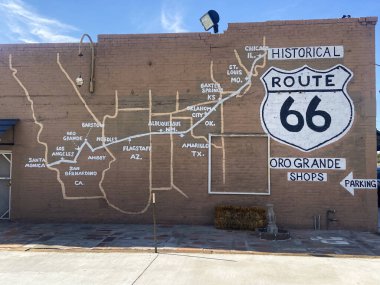 Oro Grande, Kaliforniya, ABD 27 Ağustos 2025: Ünlü otoyolun haritası ve California 'da bir binanın üzerindeki 66. Yol kalkan tabelasıyla birlikte tarihi yol 66 duvar resmi.