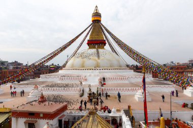 Katmandu, Nepal 8 Mart 2015: Dünyanın en büyük Budist stupalarından biri olan Boudhanath Stupa, Katmandu 'daki dini yaşamında dua bayrakları, hacılar ve güvercinlerle.