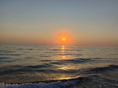 sunce iznad vode u zlatnom satu