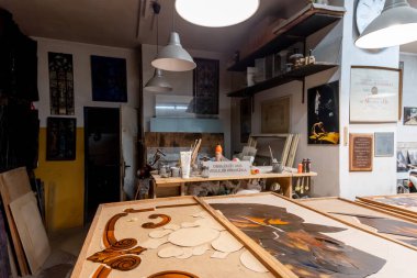 El yapımı camlar, aletler ve çalışma tezgahlarıyla geleneksel bir vitray atölyesi. Sanatsal cam işçiliğinin özgün atmosferi. Renkli cam parçaları ve boyalı cam..