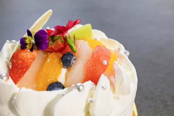 Meyve ve kremalı, yuvarlak bir kutlama pastası.