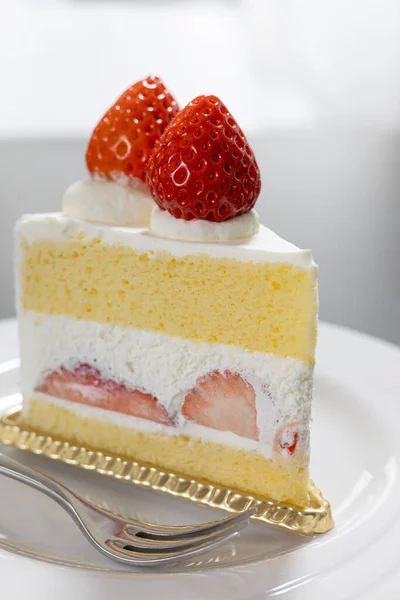 Lezzetli bir çilekli kekin dikey yakın çekimi.