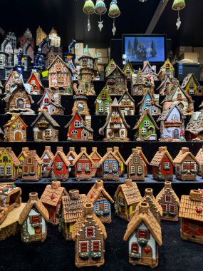 Bruges, Belçika 25 Aralık 2025. Bruges 'deki bir Noel pazarında satılık renkli seramik minyatür evler. Ayrıntılı el işleri ve küçük binalar büyüleyici bir tatil hediyesi gösterisi oluşturur..