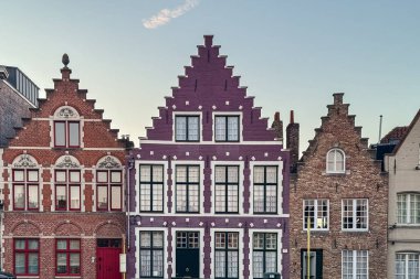 Bruges, Belçika, 26 Aralık 2025. Bruges 'deki renkli Flamanların basamaklı evleri, beyaz detaylar ve klasik çoklu camlı pencerelerle göze çarpan mor bir cephe içeriyor. Flanders 'daki eski kasaba kanal mimarisinin büyüleyici bir örneği..