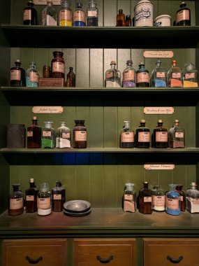 Lahey, Hollanda, 18 Ekim 2024. Madurodam parkında etiketli şişeleri ve renkli pigmentleri olan antika eczacılık rafları. Hollanda sanat mirasından esinlenilmiş kültürel kurulum.