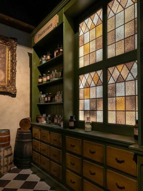 Lahey, Hollanda, 18 Ekim 2024. Ahşap dolapları, etiketli cam kavanozları ve Madurodam minyatür parkındaki dekoratif vitraylı camları olan tarihi bir eczane. Avrupa mirası iç mekan.