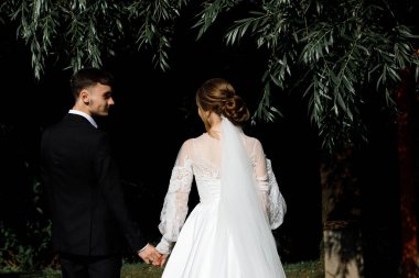 Bir çift, bir bahçe ortamında el ele yürür. Kadın beyaz bir elbise ve duvak giyer, erkek ise siyah bir takım elbise giyer. Doğayla iç içe oldukları anda mutlu görünüyorlar..