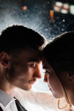 İki insan birbirine yakın durur, yumuşak bir geçmişi olan bir kutlama ortamında birbirlerine odaklanırlar. Atmosfer kıvılcım ya da ışık gösteriyor, bağlantılarını vurguluyor..