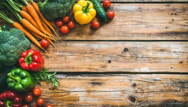 Havuç, brokoli ve biber de dahil olmak üzere taze çiğ sebzelerden oluşan canlı bir çeşitliliğin en üst görüntüsü metinler için kopyalanmış ahşap zemin üzerinde..