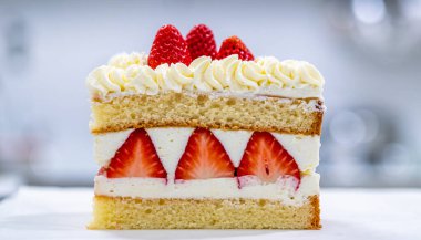 Lezzetli çilekli pasta diliminin yakın plan çekimi, nemli pasta katmanları, kremalı krema ve taze çilek dilimleri, üzeri canlı dutlarla kaplı..