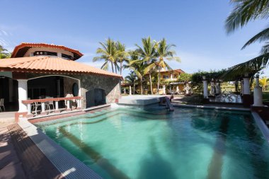 Panama Barqueta plajı 8 Ocak 2021, Las Olas tatil köyünün palmiye ağaçları arasında yüzme havuzu olan restoranın panoramik manzarası gün batımında. Çekim 8 Ocak 2021