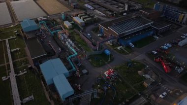 Bu gün batımında çekilmiş bir Atık Su arıtma tesisinin havadan görüntüsü. Yukarıdan çeşitli binalar, otoparklar, depolama birimleri, borular ve araçlar görünüyor.