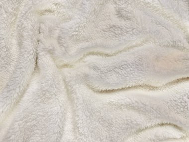 Yumuşak beyaz tüylü yün dokusu, yumuşak dalgalar halinde kıvrılarak örtülü arka plan duvar kağıdı veya giysi tasarımı için ılık kış sıcaklığını çağrıştırır..