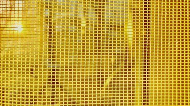 Güneş ışığıyla parlayan parlak sarı ağ örgüsü, duvar kağıdı arkaplanı veya tasarım afişi için soyut, doku yaratıyor