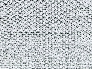 Kapalı yumuşak gri örgü kumaş dokusu karmaşık dikiş deseni ile arka plan duvar kâğıdı veya afiş alanı için samimi kış sıcaklığını çağrıştırıyor