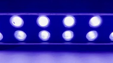 Koyu mor ambianslı parlak ışık çubuğu sırası karanlık stüdyo teknoloji afişi ya da fütüristik duvar kağıdı için kapanıyor