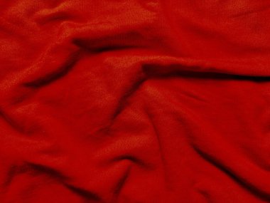 Yumuşak kıvrımlarda kıvrılan kırmızı kumaş kırışıklıkları makro doku dizayn arkaplanları için canlı sıcaklığı çağrıştırıyor.