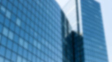 Modern bir mavi cam gökdelen, parlak ve çağdaş kentsel iş bölgesini temsil eden gökyüzünü yansıtır..