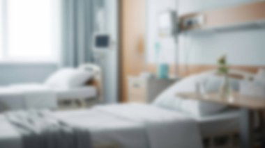 Temiz ve parlak bir hastane odası. İçinde iki boş yatak, monitör gibi tıbbi ekipmanlar ve sehpasında çiçek olan küçük bir vazo var. İyileşme ve umut olduğunu gösteriyor..