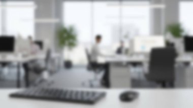 Masalarında çalışan insanların bulanık figürleriyle aydınlık ve modern bir ofis..