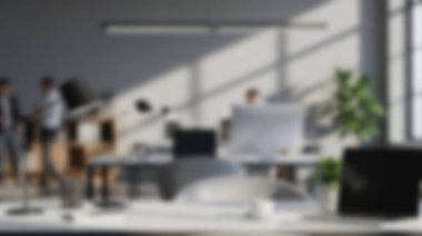 Parlak, modern bir ofis, masalarında çalışan çalışanların bulanık figürleriyle doğal ışıkla yıkanmış..