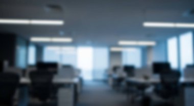 Geniş pencereli iş istasyonları olan bulanık modern ofis içi.